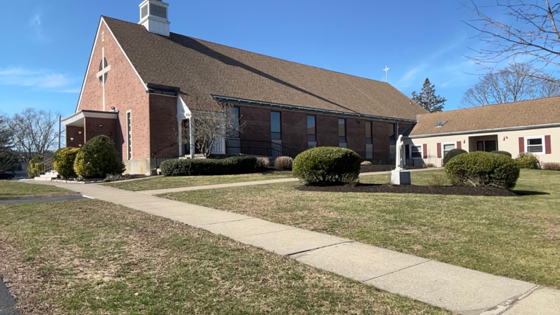 A brick church in the East Bay with trimmed shrubs, mulched beds, and maintained grounds — a LawnCheck commercial property