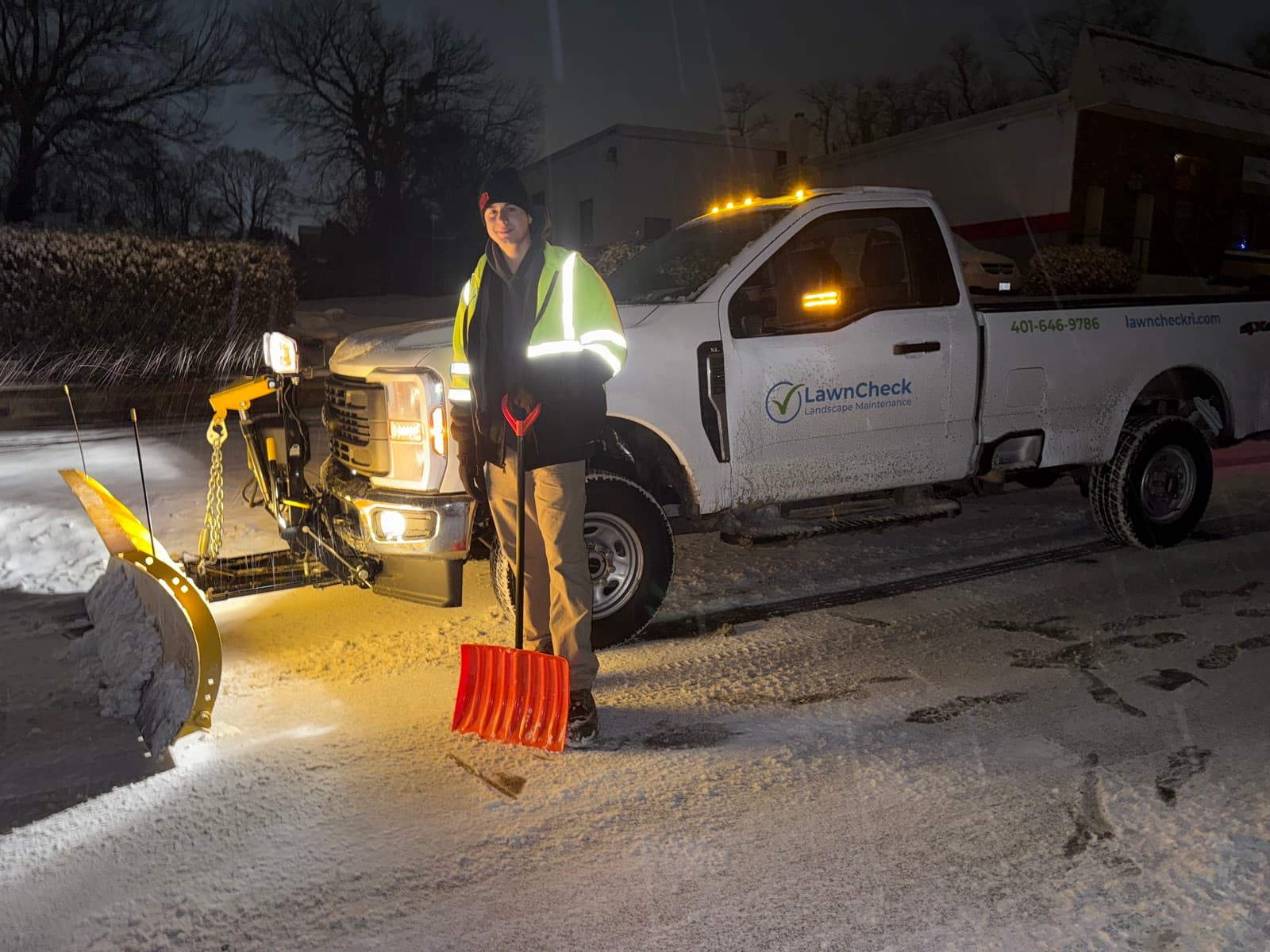 LawnCheck plow truck clearing a commercial lot at night