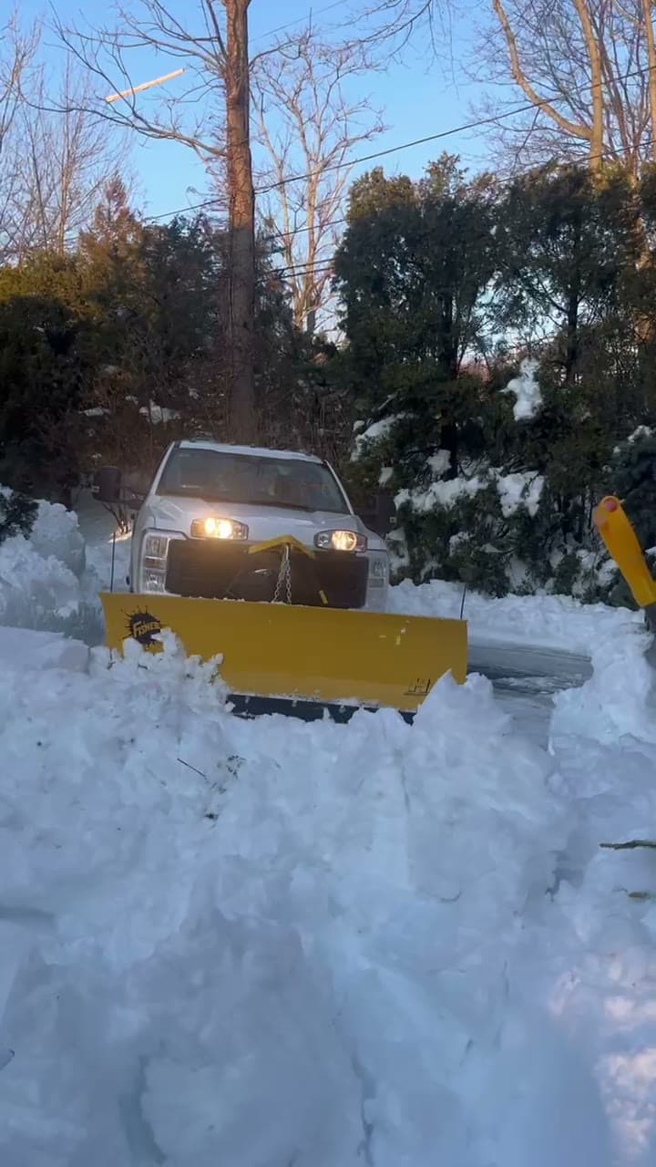 A LawnCheck plow truck clearing snow in the East Bay