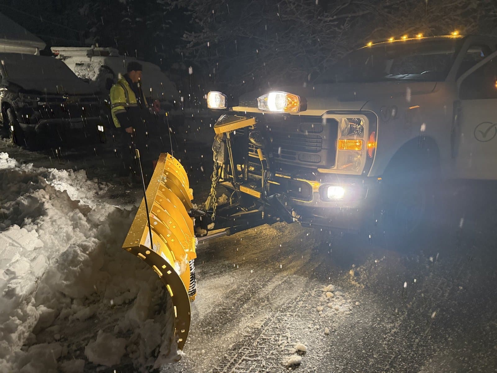 The plow truck pushing snow at night